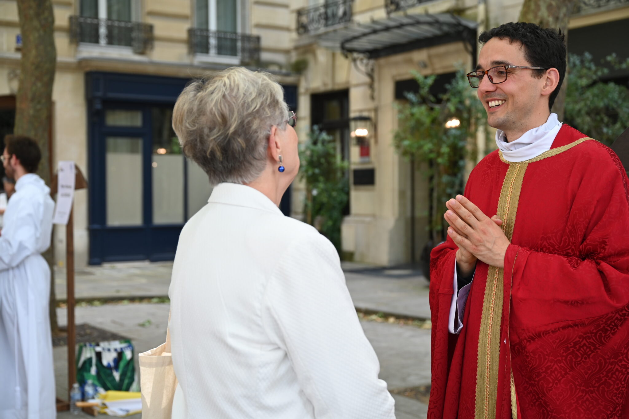 jeune prêtre discutant avec une femme qui est de dos